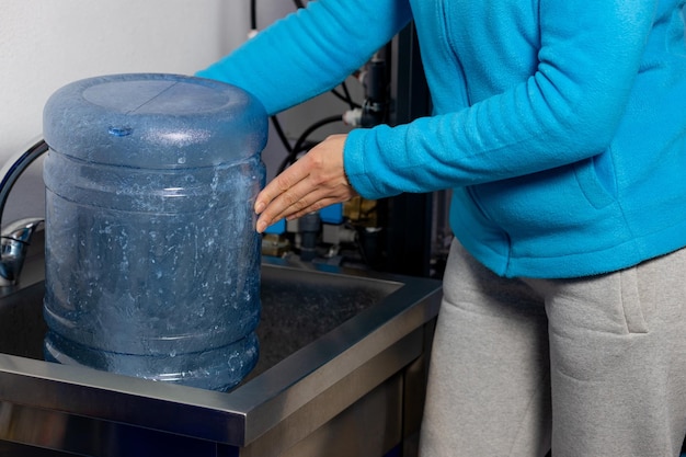 Le processus de nettoyage des bouteilles avant de les remplir avec de l'eau Gros plan sur le lavage des mains d'une femme