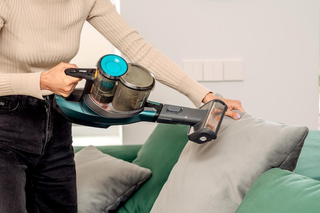 Le processus de nettoyage d'un canapé avec un aspirateur avec une buse spéciale