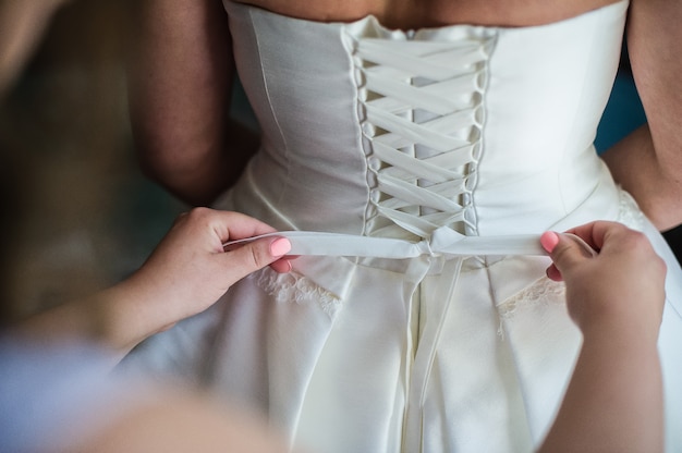 Le processus de nouer une robe de mariée, vue arrière