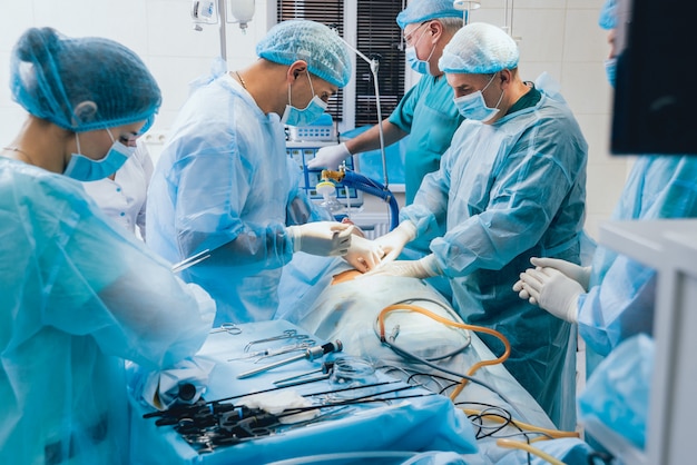 Processus d'opération de chirurgie gynécologique utilisant un équipement laparoscopique. Groupe de chirurgiens en salle d'opération avec équipement de chirurgie