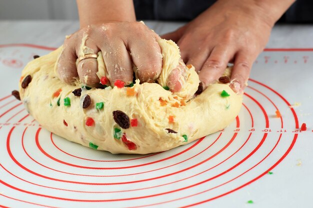 Processus de pétrissage de la pâte crue du gâteau allemand Stollen de Noël dans la cuisine