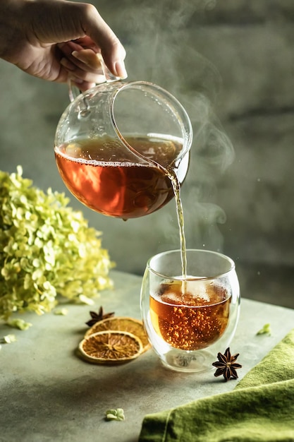 Photo processus de préparation du thé. une tasse de thé fraîchement préparé avec des bulles et de la vapeur sur fond texturé
