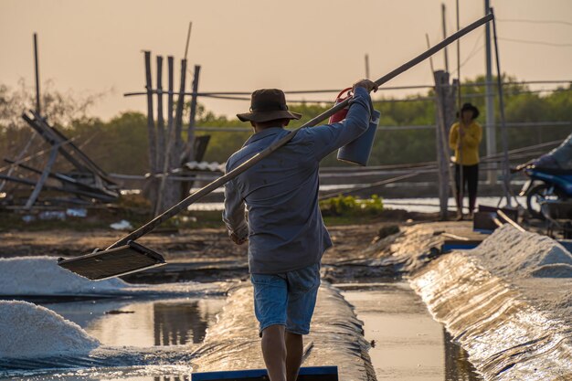 Processus de sel de mer fabriqué à partir d'un tas de sel dans la saline par un travailleur du sel dans la zone rurale de Long Dien Ba Ria Vung Tau Les champs de sel sont l'une des destinations les plus uniques au Viet Nam