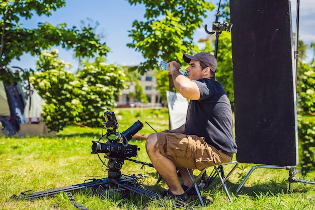 Processus de tournage sur scène de cinéma - ensemble de production commerciale, emplacement extérieur.Un caméraman professionnel exploite la caméra.