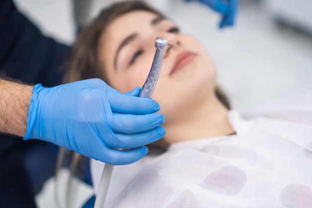 Processus de traitement des dents dans une clinique de dentisterie moderne médecin tenant un outil dentaire prêt à travailler