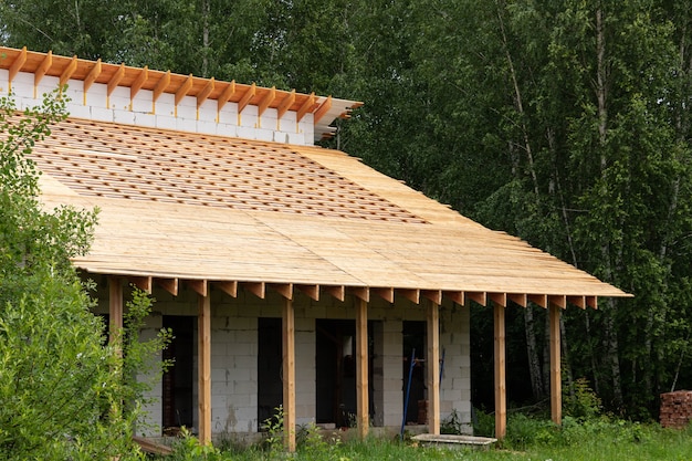 Processus de travail, construction de banlieue à partir de blocs de silicate et de silicate de gaz et de bois. La charpente d'une maison à un étage avec un toit.