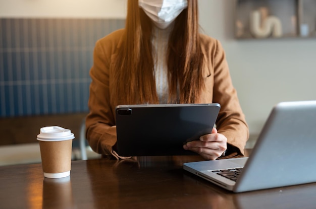 Processus de travail dans le bureau moderne. Jeune femme gestionnaire de compte travaillant à la table en bois avec un nouveau projet d'entreprise. Clavier de saisie, Utilisation d'un ordinateur portable contemporain. Horizontal.