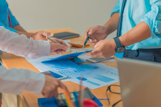 Processus de travail en équipe. Équipage de jeunes chefs d&#39;entreprise travaillant avec un nouveau projet de démarrage. tablette sur la table en bois, clavier de frappe, message de texte, analyser les plans de graphe