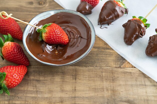 Processus de trempage des fraises au chocolat dans l'espace de copie de chocolat