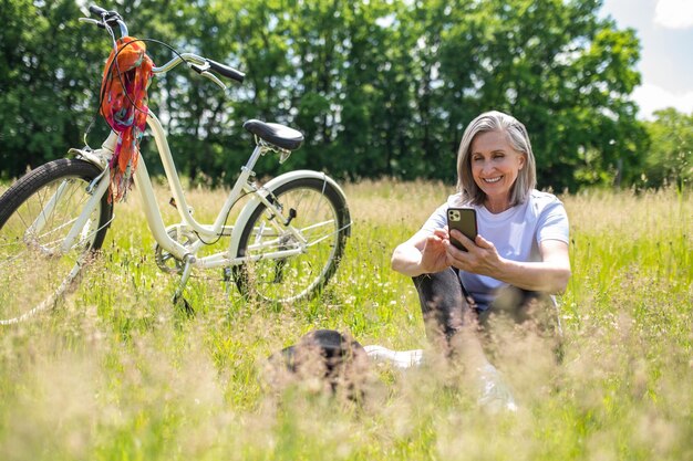 Proche de la nature. Une femme avec un vélo passe du temps près de la nature