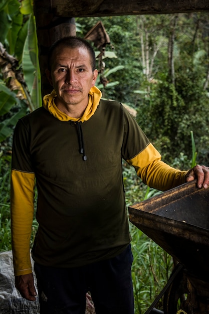 Producteur de café d'Amérique latine travaillant dans la récolte avec ses plantes et séchant le café dans la jungle