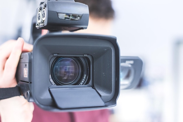 Production cinématographique professionnelle Le cinéaste masculin enregistre avec une caméra professionnelle Gros plan sur l'objectif de la caméra