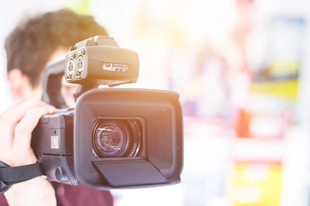 Production cinématographique professionnelle Le cinéaste masculin enregistre avec une caméra professionnelle Gros plan sur l'objectif de la caméra