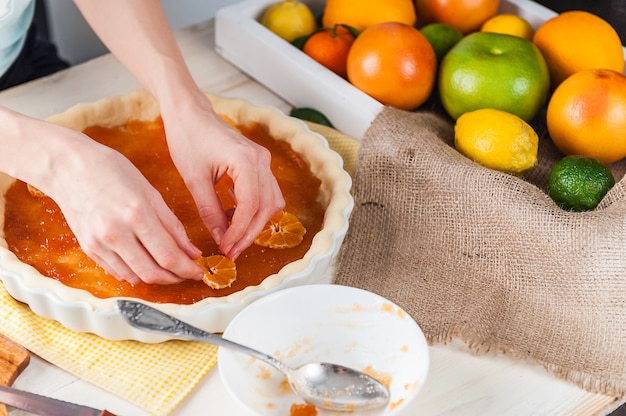 Production de gâteau avec marmelade d'agrumes et tranches de mandarine