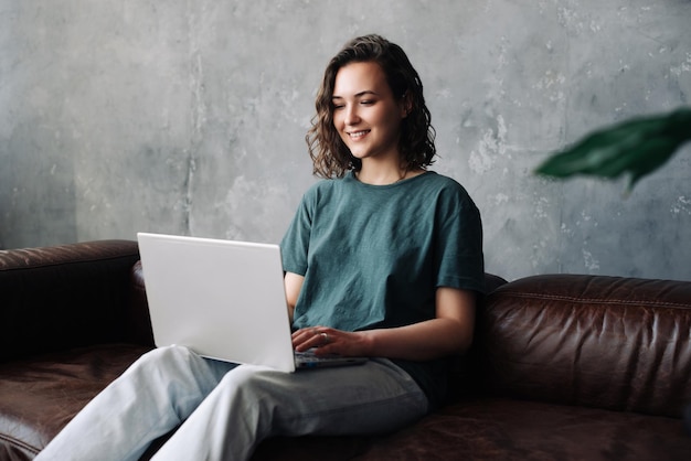 Productivité et indépendance une jeune femme s'engage dans le travail à distance et étudie en utilisant un ordinateur portable dans le