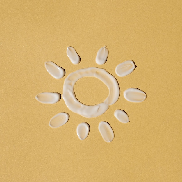 Produit de beauté Sun fait de frottis de crème cosmétique blanche sur fond jaune clair