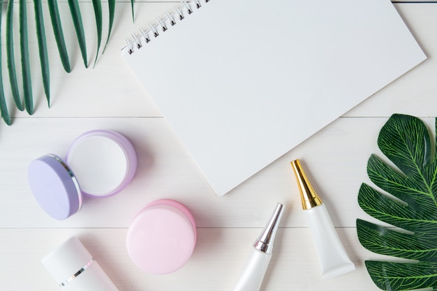 Photo produit cosmétique et de soin de la peau, cahier et feuilles sur la table