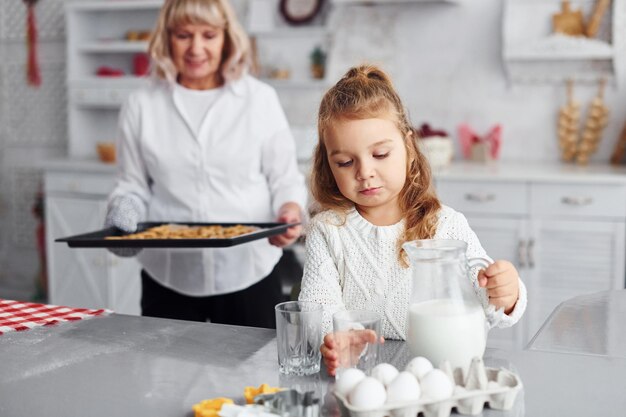 Produit fini Grand-mère aînée avec sa petite-fille prépare des bonbons pour Noël dans la cuisine