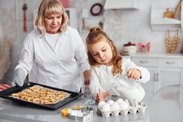 Produit fini Grand-mère aînée avec sa petite-fille prépare des bonbons pour Noël dans la cuisine