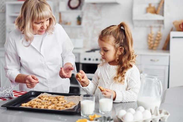 Produit fini Grand-mère aînée avec sa petite-fille prépare des bonbons pour Noël dans la cuisine