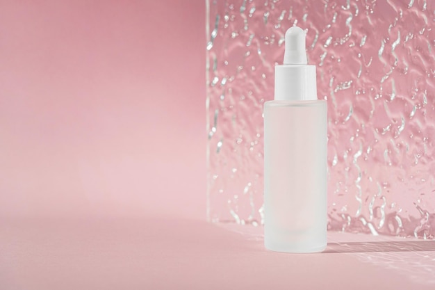 Produit liquide transparent dans une bouteille en verre Sérum anti-âge au collagène et aux peptides sur une surface rose avec une feuille acrylique nervurée Maquette d'huile d'acide hyaluronique Maquette de produit de beauté Bannière