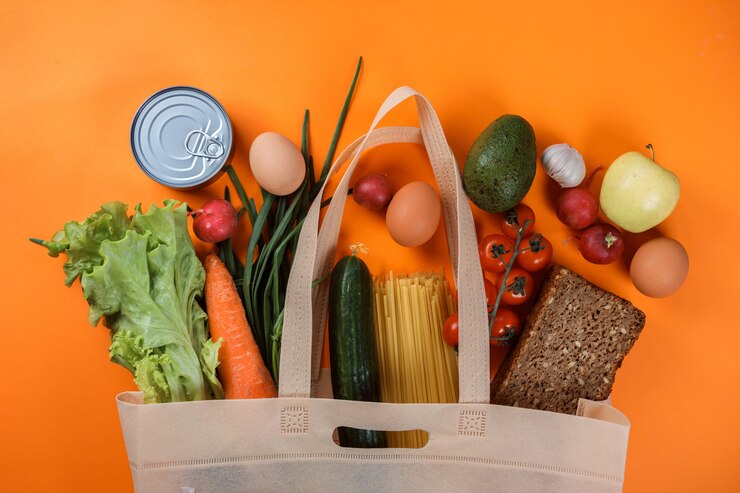 Photo produits alimentaires dans le sac à provisions sur orange.