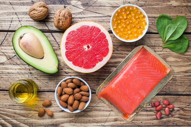 Produits antioxydants d&#39;aliments sains: poisson et avocat, noix et huile de poisson, pamplemousse sur fond en bois.