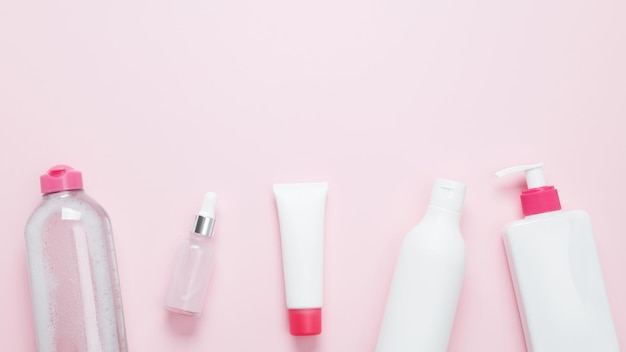 Produits de beauté cosmétiques sur fond rose Bouteilles et tubes avec mock-up de marque