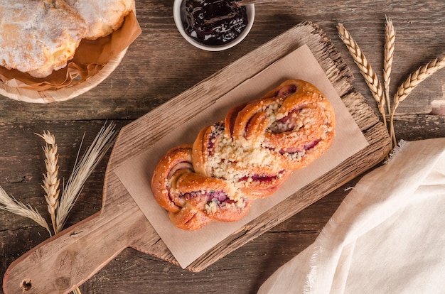 Produits de boulangerie frais - délicieux pain en osier avec remplissage sur fond de bois