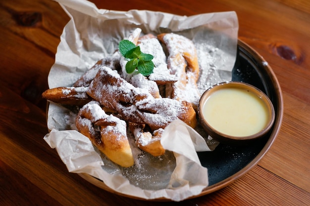 Produits de boulangerie frais avec du sucre en poudre garni d'une vue de côté de feuille de menthe