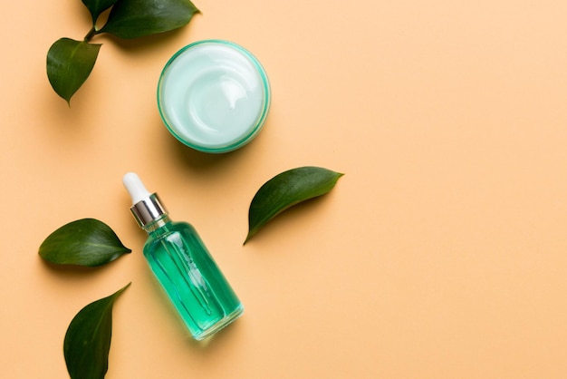 Produits cosmétiques biologiques avec des feuilles vertes sur fond de couleur Copier l'espace à plat