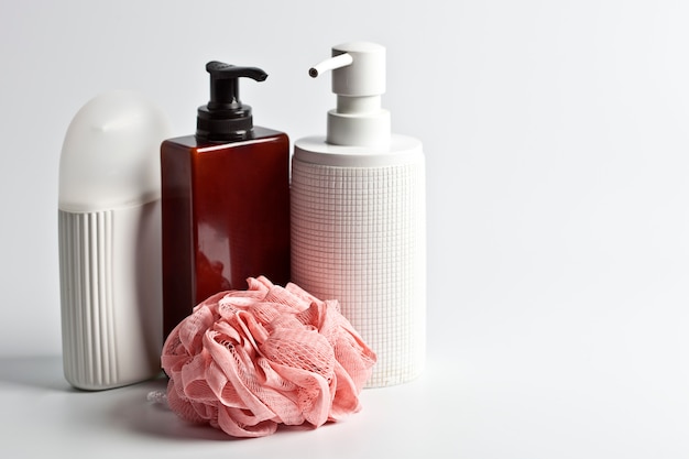 Photo produits cosmétiques pour le bain et éponge blanche à la lumière