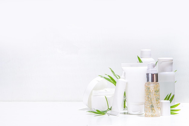 Produits cosmétiques de soins de la peau de beauté sur fond blanc avec des feuilles de palmier tropical espace de copie flatlay