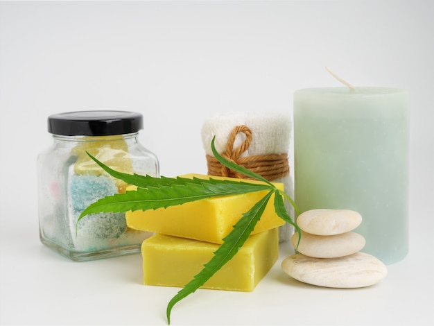 Produits d'extrait de chanvre de station thermale avec la barre de savon de feuille de cannabis et la pierre blanche de serviette sur le fond blanc