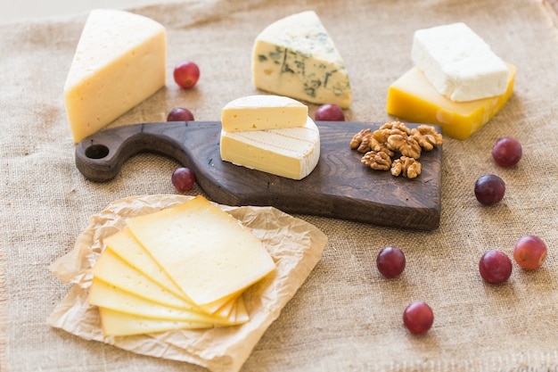 Produits frais. Fromage, brie, camembert, raisins et noix sur table rustique.