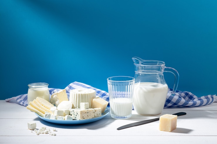 Photo produits laitiers sur base en bois blanc et fond bleu.