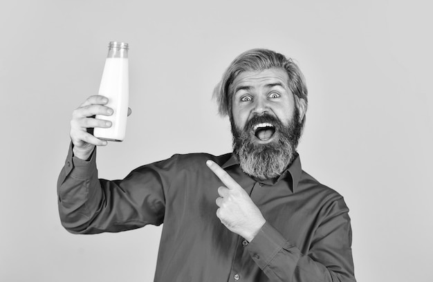 Produits laitiers à base de lait pour adultes et enfants agriculteur heureux présent homme barbu en verre boire du lait utile amour lait moustache nourriture et boisson concept utilité du lait pointant du doigt