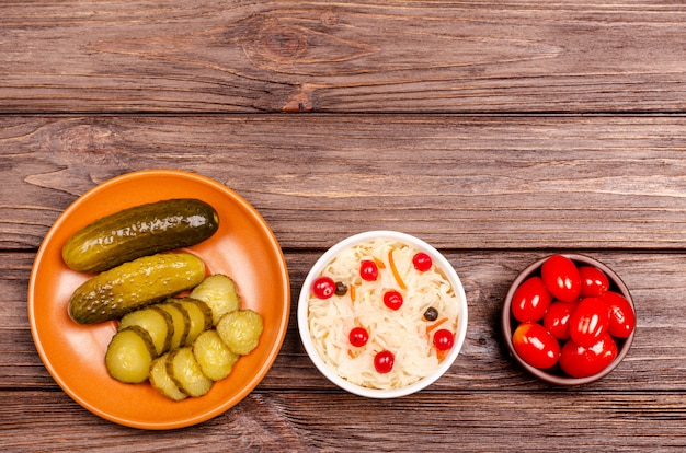 Produits laitiers fermentés savoureux faits maison sur assiettes - choucroute, tomates, cornichons