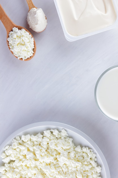 Produits laitiers sur un tableau blanc. Fromage cottage, crème et fromage à pâte molle sur fond blanc