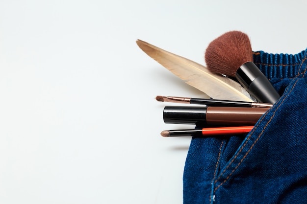 Produits de maquillage et produits de beauté cosmétiques déversés sur un jean en denim pour femme