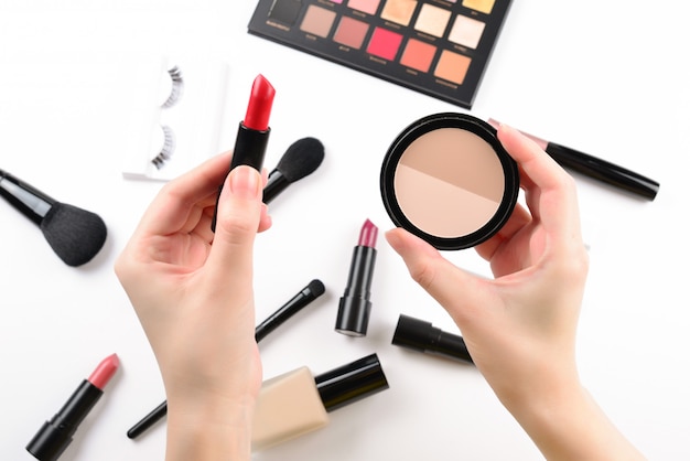 Produits de maquillage professionnels avec produits de beauté cosmétiques, fond de teint, rouge à lèvres, ombres à paupières, cils, pinceaux et outils.