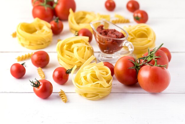 Produits de pâtes à la tomate Fromage Pâtes crues Fusili Fettuccine Ingrédients Cuisine italienne