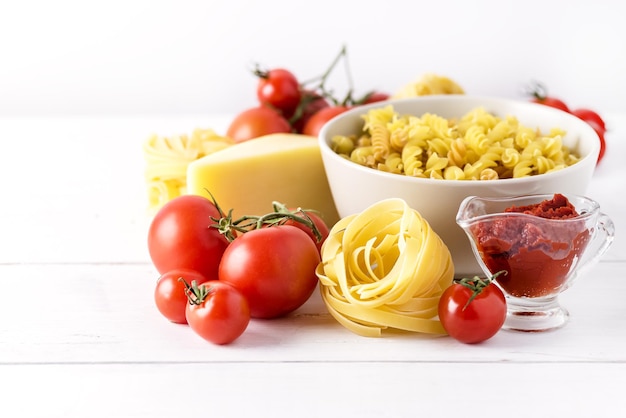 Produits de pâtes à la tomate Fromage Pâtes crues Fusili Fettuccine Ingrédients Cuisine italienne