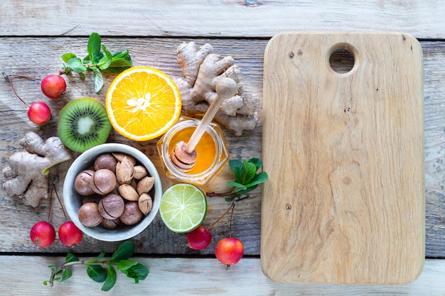 Des produits sains pour renforcer l'immunité sur fond en bois avec vue de dessus de l'espace de copie. Citron, noix, gingembre au système immunitaire