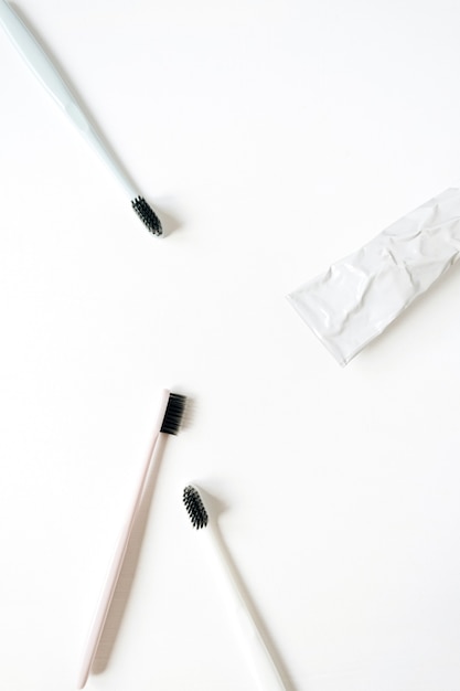 Photo produits de soins bucco-dentaires: brosses à dents, dentifrice sur fond blanc