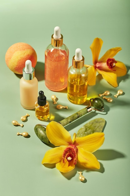 Produits de soins cosmétiques dans des bouteilles en verre avec des sérums de fleurs d'orchidées des huiles de gel crème Concept pour les soins du visage et du corps bien-être et spa relaxation tropicale