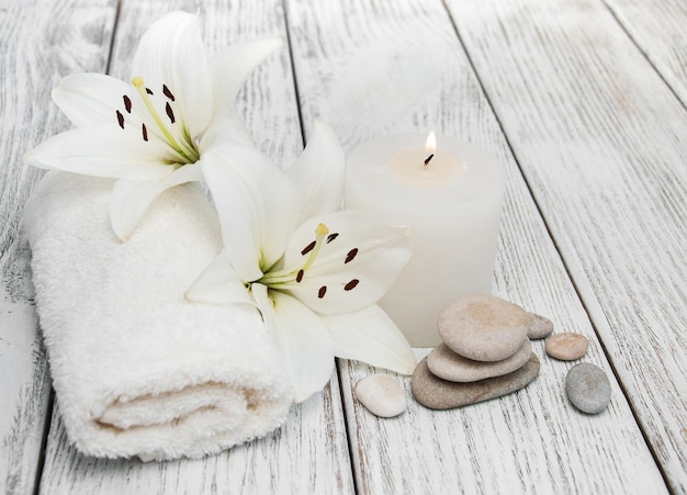 Produits de spa avec lys blanc sur un vieux fond en bois