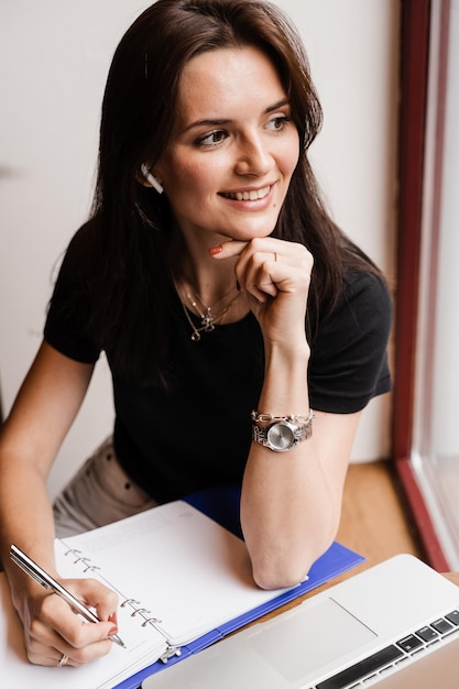 Un professeur d'anglais concentré avec un ordinateur portable suit une leçon en ligne via la communication vidéo Apprentissage à distance Jolie fille tapant et discutant sur un ordinateur portable au café