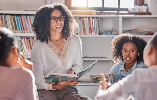 Professeur de conte ou élèves ayant des questions dans une salle de classe ou une bibliothèque pour le développement de l'apprentissage Éducation des enfants ou des enfants écoutant une femme noire demander des commentaires sur des livres amusants à l'école