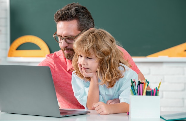 Professeur d'école avec un écolier apprenant à l'ordinateur portable étudiant avec un professeur d'éducation en ligne